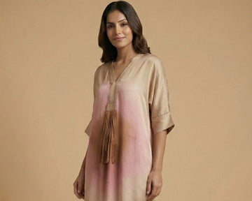 Woman wearing a beige and pink gradient dress on a beige background
