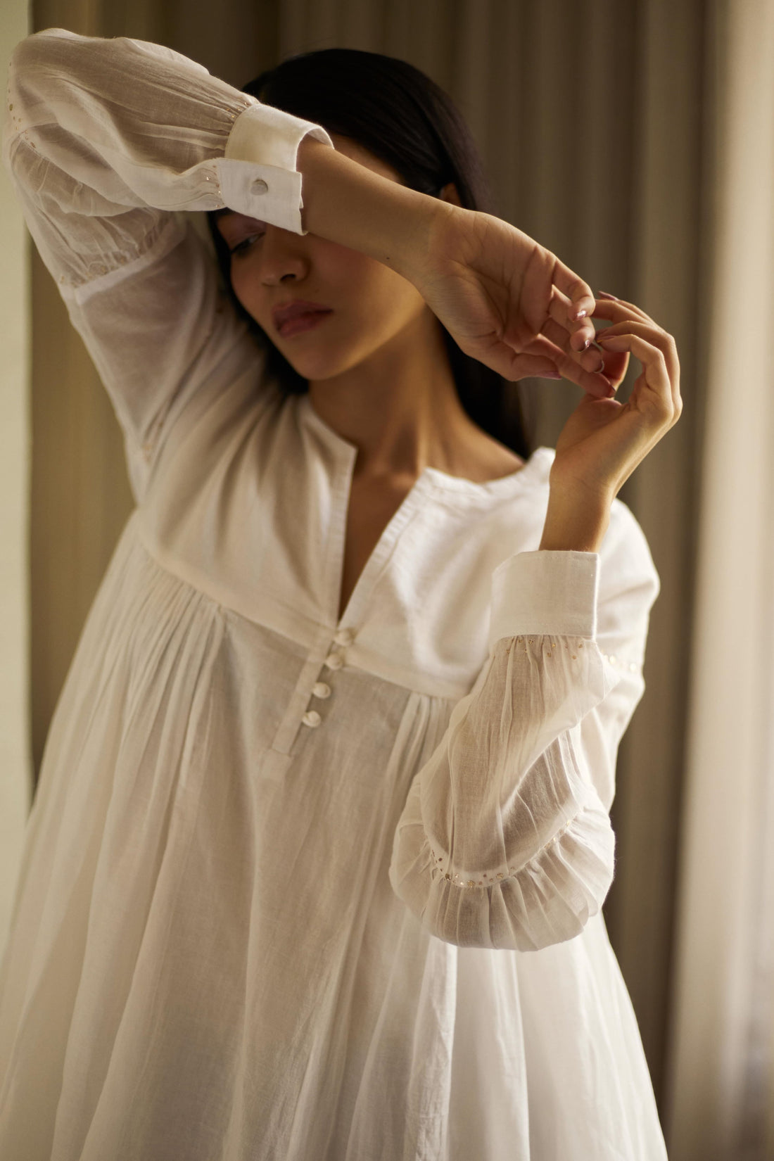 Woman wearing a white blouse with a neutral background